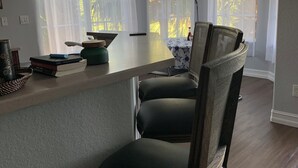 Keittiössä on ruokailutila, jossa on puinen ruokapöytä, tuoleja ja keittiötaso.