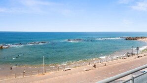 Una carretera costera con una playa y afloramientos rocosos.