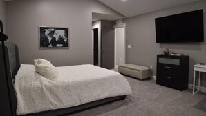 Ein Schlafzimmer mit einem Bett, einem Schminktisch, einem Fernseher und einer Weltkarte an der Wand.