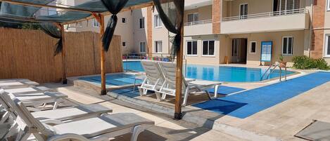 Seasonal outdoor pool, open 9:00 AM to 7:00 PM, pool loungers
