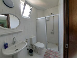 A bathroom with a sink, toilet, and shower.