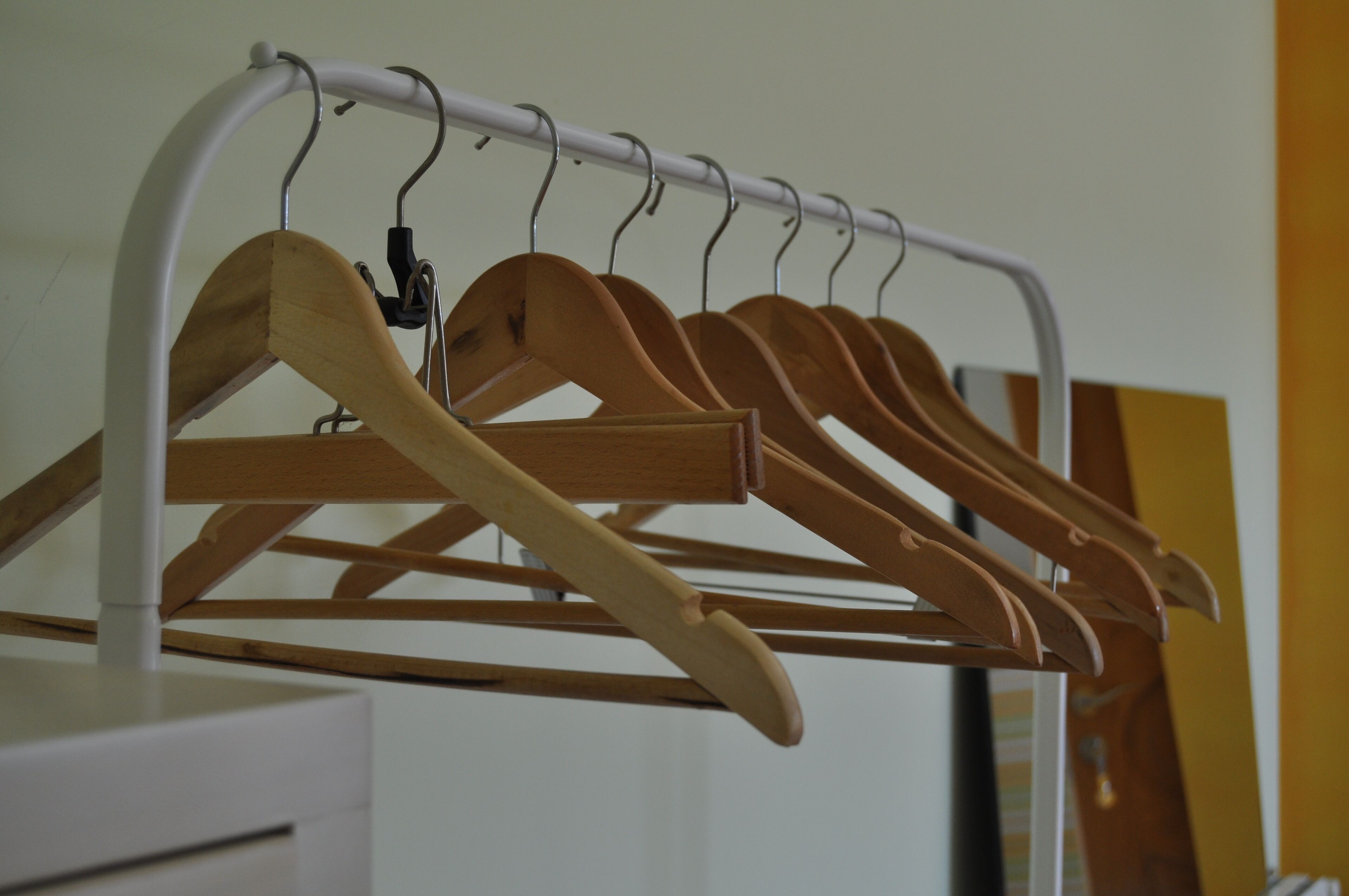 Un portant à vêtements avec des cintres en bois.