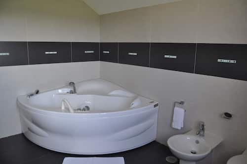 Habitación cuádruple Deluxe, vistas parciales al mar | Baño | Ducha, secador de pelo, toallas y jabón