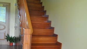 A wooden staircase with a handrail, leading to an upper floor.