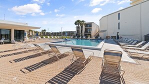 A pool area with sun loungers and a swimming pool. - 2BR Condo Sleeps 6 – Pool & Steps to the Beach (Panama City Beach)