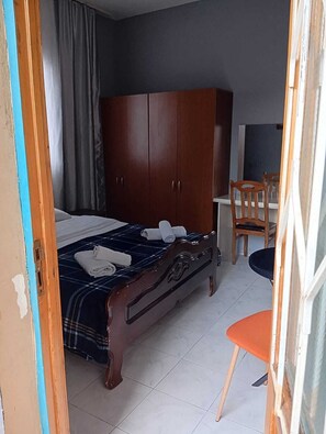 A bedroom with a bed, a wardrobe, a desk, and a chair. - ali nino (Batumi)
