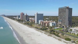 A coastal hotel area with beachfront properties, including high-rise buildings and smaller residential structures. - Ocean Forest Plaza 606 -1BR/1BA- Pool (Myrtle Beach)