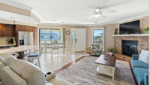 A spacious living area with a fireplace, a dining area with a view, and a kitchen with modern appliances. - Tilghman Lakes C4- 2BR/2BA- 2nd Row, Pool (North Myrtle Beach)