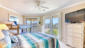 A bedroom with a bed, a TV, a ceiling fan, a dresser, and a balcony with a view. - Tilghman Lakes C4- 2BR/2BA- 2nd Row, Pool (North Myrtle Beach)