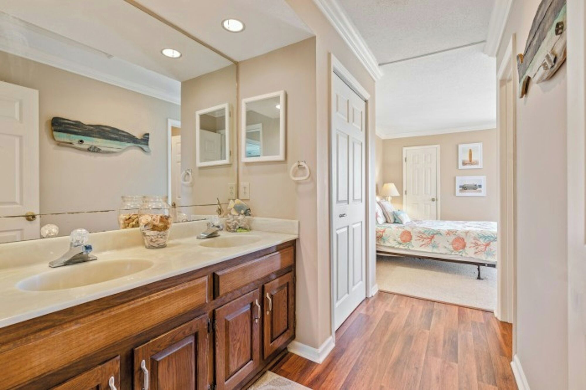 A bathroom with two sinks, wooden cabinets, and a large mirror.