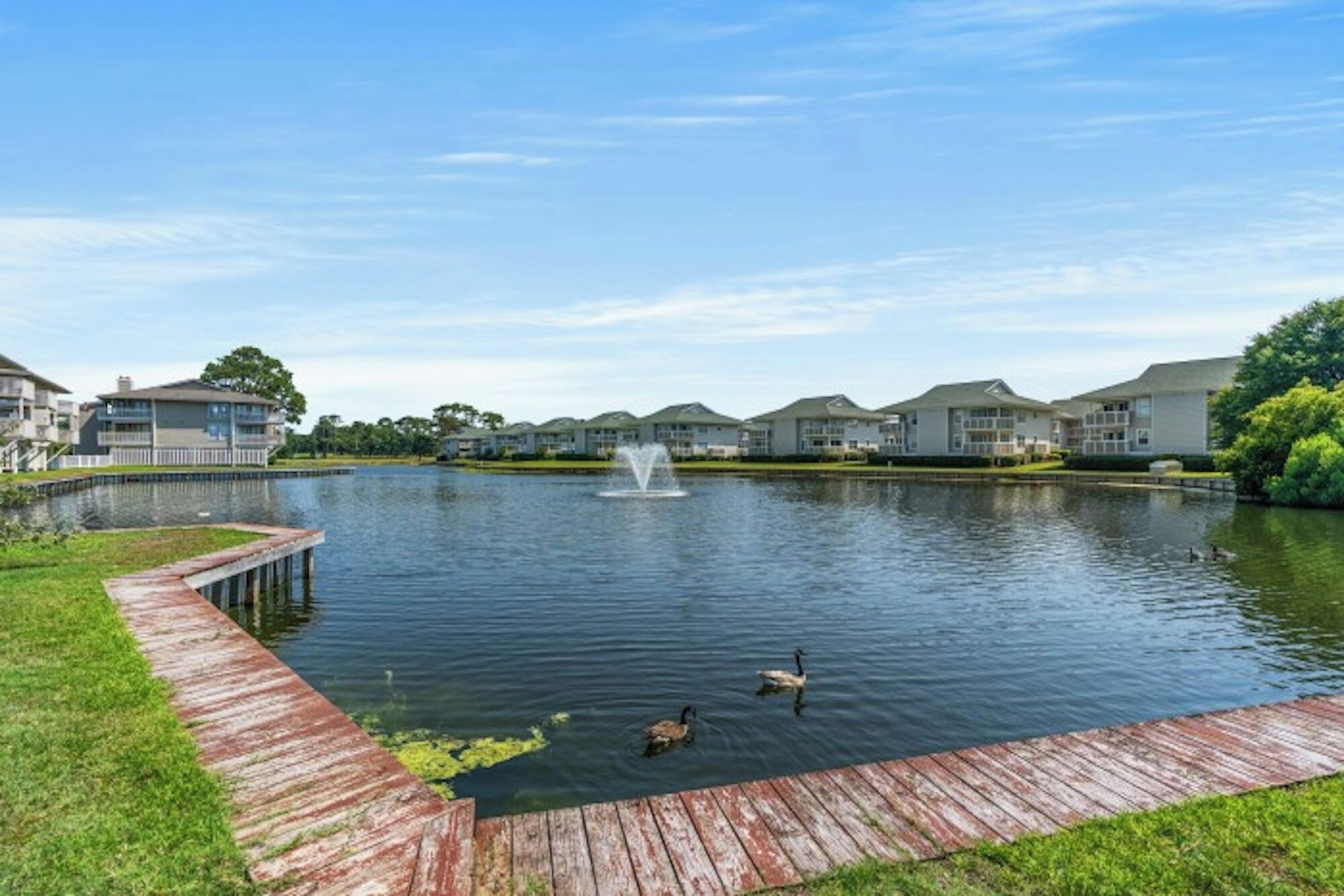 Un lago con una fuente, rodeado de edificios residenciales.