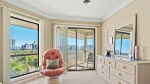 A room with a large sliding glass door leading to a balcony with a view of buildings and greenery. - Tilghman Lakes C4- 2BR/2BA- 2nd Row, Pool (North Myrtle Beach)