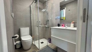 A modern bathroom with a glass-enclosed shower, a toilet, and a vanity with a mirror. - Calanegra Apartment with Private Pool - Ground Floor - Puerto de Mazarrón (Mazarrón)