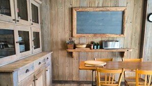 A rustic kitchen with wooden cabinets, a chalkboard, and a wooden dining table with chairs. - Apartment in residence near the Mont d'Arbois (Megève)