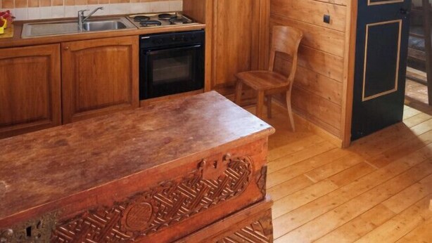 A wooden kitchen with cabinets, a stove, and a sink. - Apartment with fireplace near the Vauban City (Briançon)