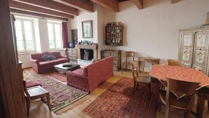 A cozy living room with a fireplace, a sofa, a coffee table, and a dining table with chairs. - Apartment with fireplace near the Vauban City (Briançon)