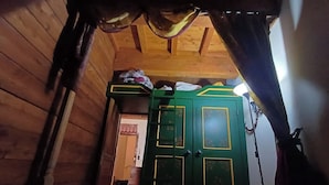 A wooden interior with a green door, a wooden ceiling, and a visible hallway. - Apartment with fireplace near the Vauban City (Briançon)