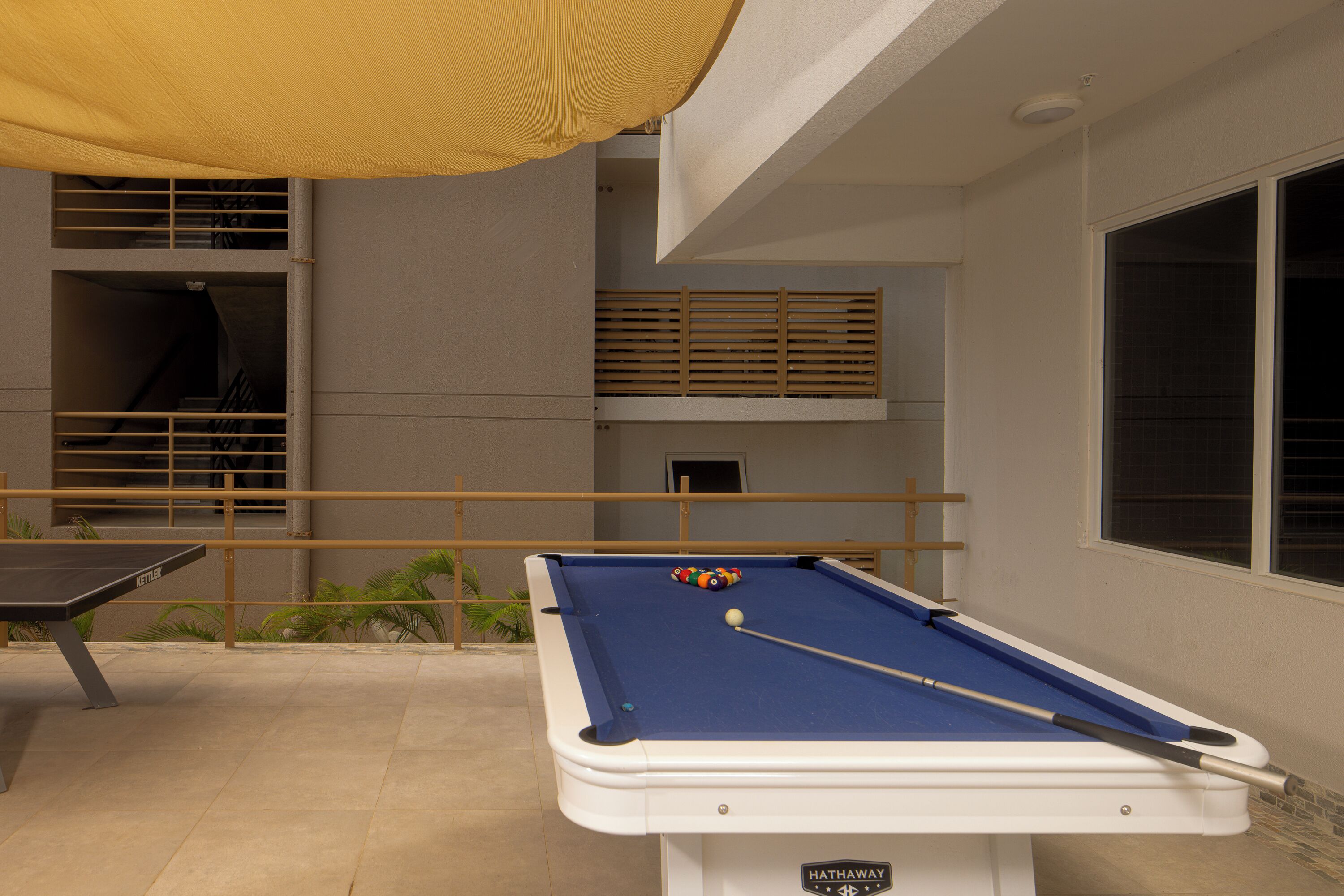 A pool table with a blue felt surface, a pool cue, and a colorful ball.