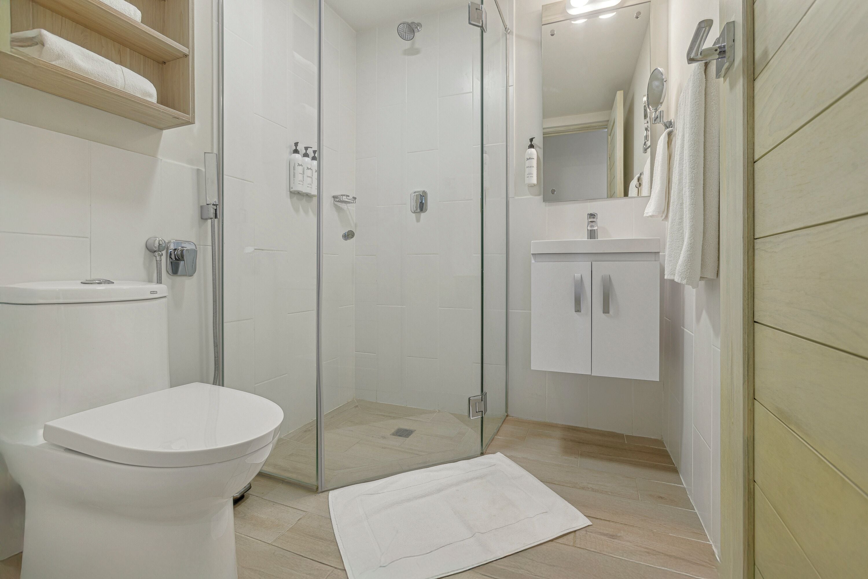 A modern bathroom with a toilet, shower, and sink.