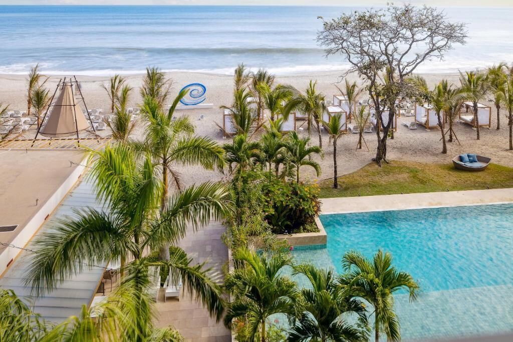 Ein Resort mit Pool, Strand und Palmen.