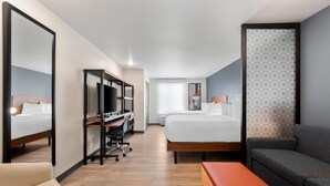 A hotel room with a bed, a desk with a computer, a chair, a sofa, and a large mirror. - Everhome Suites Amarillo West - Medical Center (Amarillo)