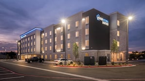A modern hotel with multiple floors, a parking lot, and a well-lit entrance. - Everhome Suites Amarillo West - Medical Center (Amarillo)