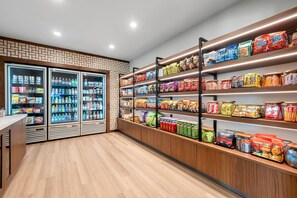 A well-lit snack and beverage section with refrigerated drinks, shelves of packaged snacks, and a clean, modern design. - Everhome Suites Amarillo West - Medical Center (Amarillo)