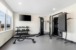 A gym with a bench, dumbbells, and a pull-up bar. - Everhome Suites Amarillo West - Medical Center (Amarillo)