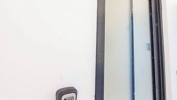 Un edificio blanco con una puerta negra y un teclado electrónico.
