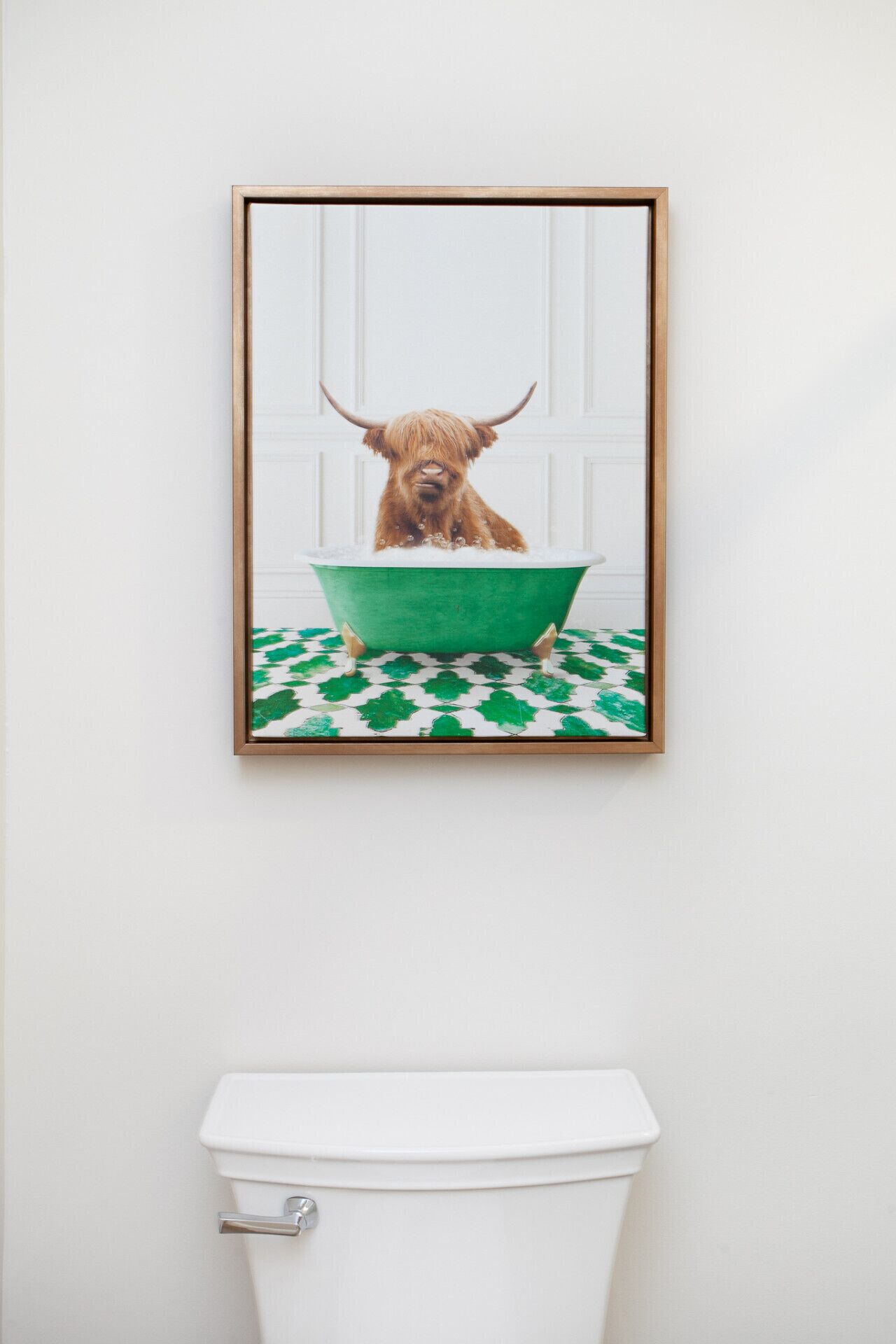 Fotografía enmarco de un perro en una bañera sobre un piso verde y blanco estampado, colgada sobre un inodoro blanco.