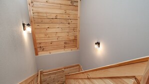 Un escalier en bois avec une rampe en bois et un panneau mural en bois.