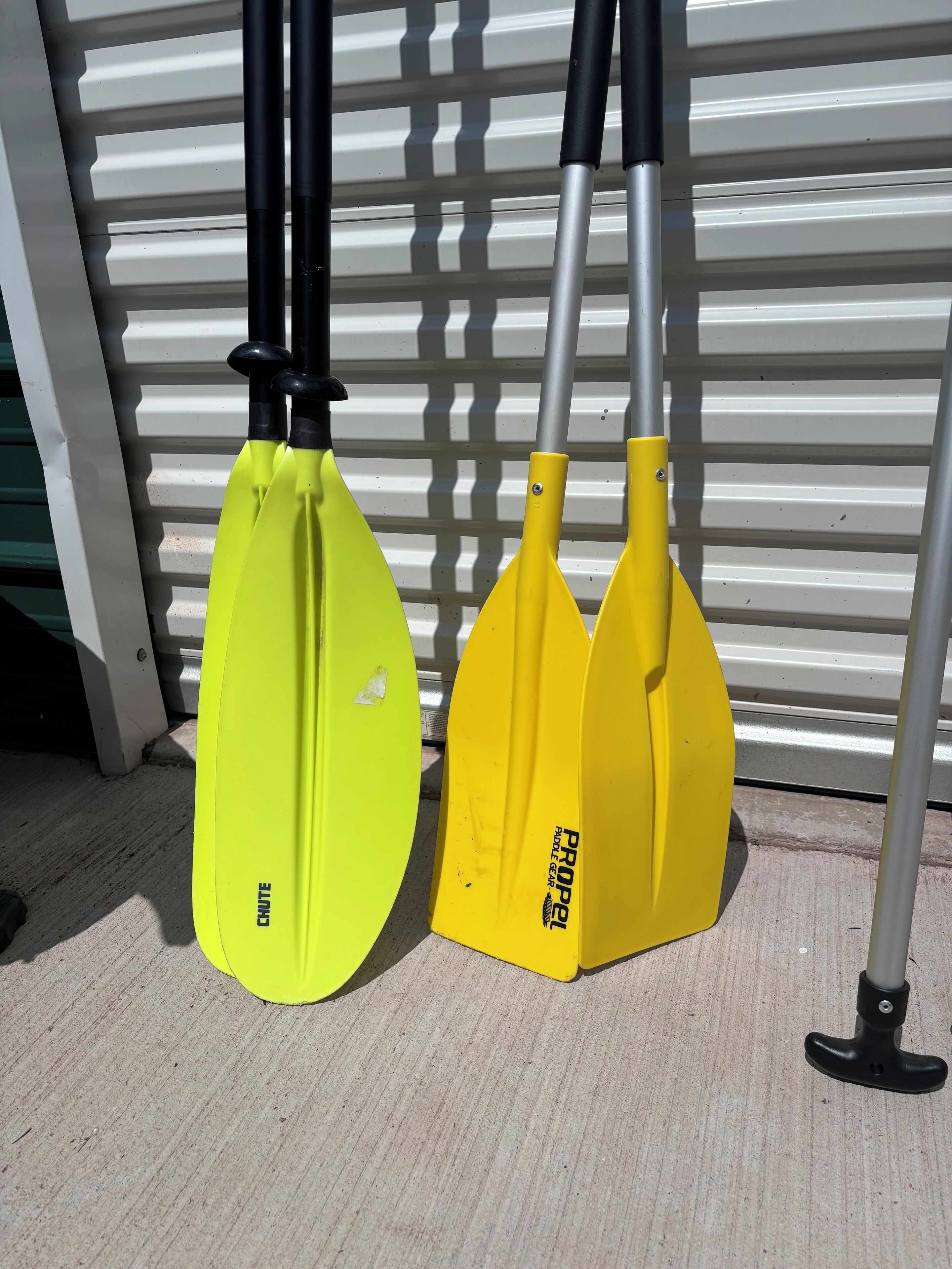 Twee paddleboards, één geel en één groen, staan rechtop voor een witte achtergrond.