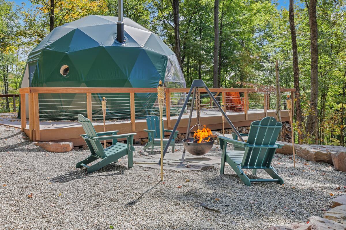 A geodesic dome structure with a fire pit and seating area.