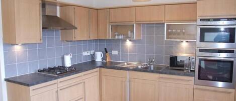 Apartamento | Cozinha privada | Geladeira, micro-ondas, fogão, cooktop