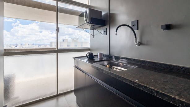 A modern kitchen with a large window, a built-in stove, and a stainless steel sink. - Copan 203e in S o Paulo (São Paulo)