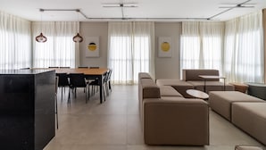 Ein modernes Wohnzimmer mit Essbereich, ausgestattet mit einer Sofagarnitur, einem Couchtisch und einem Esstisch mit Stühlen.