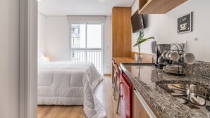 Eine moderne Küche mit Granitarbeitsplatte, Spüle aus Edelstahl und Holzboden.