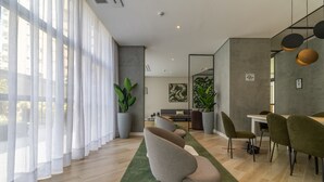 A modern living room with a sofa, dining table, chairs, and large windows with sheer curtains. - Sa1342-514 in S o Paulo (São Paulo)