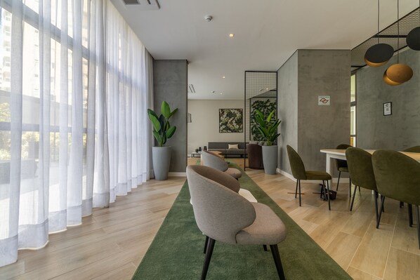A modern living room with a sofa, dining table, chairs, and large windows with sheer curtains. - Sa1342-514 in S o Paulo (São Paulo)