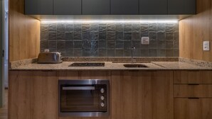 A modern kitchen with wooden cabinets, a built-in oven, a toaster, and a tiled backsplash. - Sa1342-514 in S o Paulo (São Paulo)