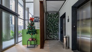 A modern hallway with a Christmas tree, a trash bin, and an elevator. - Sa1342-514 in S o Paulo (São Paulo)
