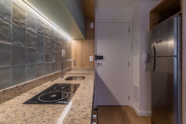 A modern kitchen with a built-in stove, a sink, and a stainless steel refrigerator. - Sa1342-514 in S o Paulo (São Paulo)