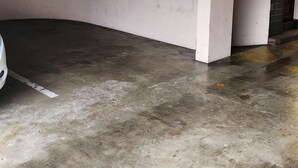 Um quarto com teto arredondado, parede branca e chão de concreto.