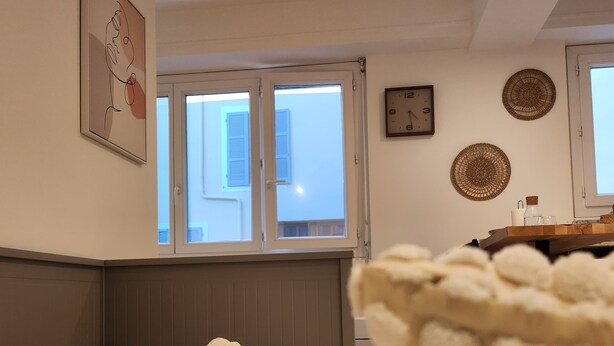 Quarto com cama, janela, relógio e um adorno na parede.