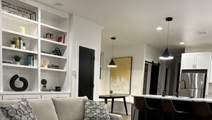 Een moderne woonkamer met een bank, salontafel en inbouwplanken.