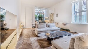 Un salon moderne comprenant un canapé, une table basse et un coin repas avec des chaises.