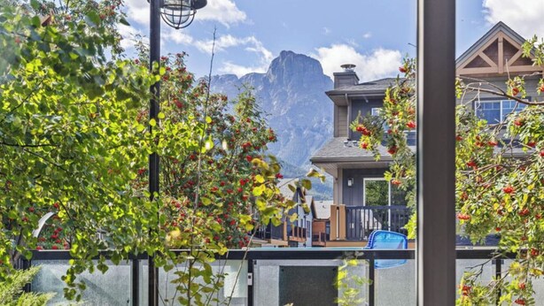Zona residencial amb muntanyes al fons, piscina i casa amb terrassa.