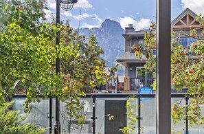 A residential area with a mountain backdrop, a swimming pool, and a house with a deck.