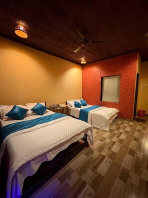 A hotel room with two beds, a ceiling fan, and a window. - Chardara Agro Tourism (Jaoli)