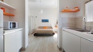 Een moderne, open woonruimte met keuken, bed en uitzicht op de stad.
